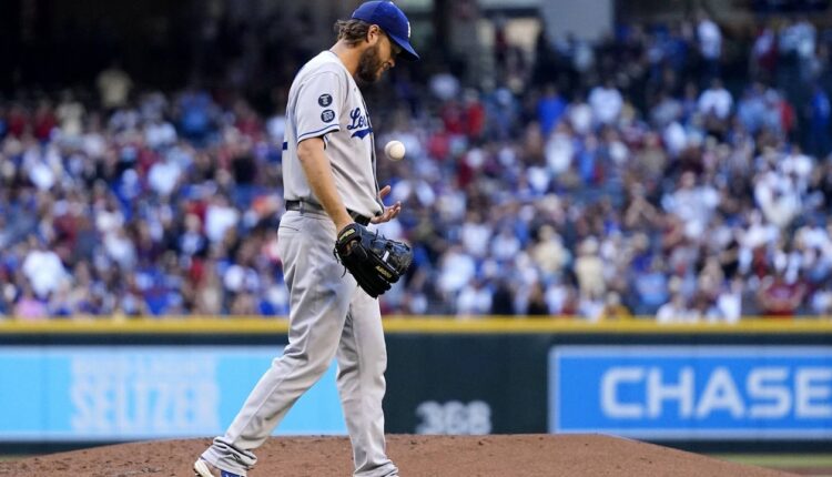 Los Angeles Dodgers starting pitcher Clayton Kershaw flips a new baseball in the air after giving up a home run to Arizona Diamondbacks' Carson Kelly during the second inning of a baseball game Saturday, Sept. 25, 2021, in Phoenix. (AP Photo/Ross D. Franklin)