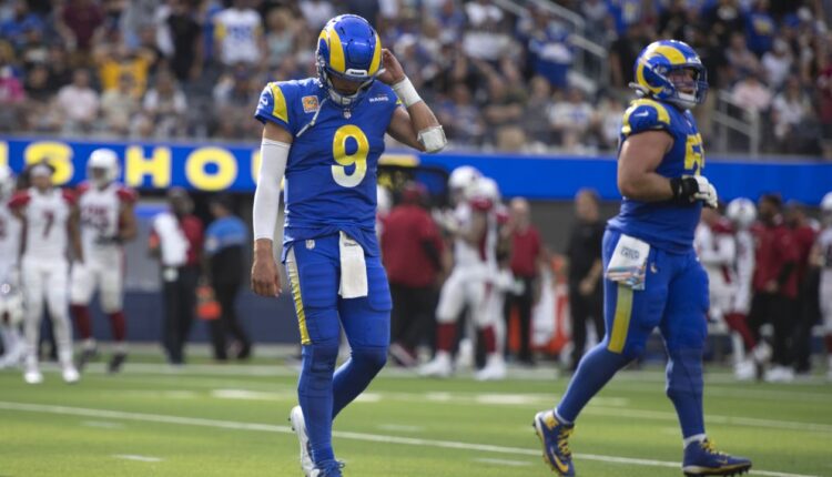 Los Angeles Rams quarterback Matthew Stafford (9), left, unbuckles his helmet strap after the team could not convert the fourth down during an NFL football game against the Arizona Cardinals Sunday, Oct. 3, 2021, in Inglewood, Calif. (AP Photo/Kyusung Gong)