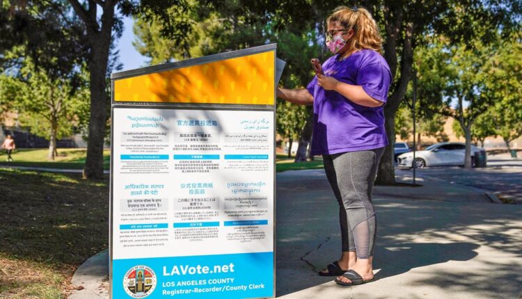 In this Oct. 14, 2020, file photo, a citizen drops her ballot at an official ballot drop box in Santa Clarita, Calif. (AP Photo/Marcio Jose Sanchez)