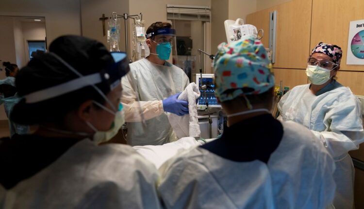 In this Nov. 19, 2020, file photo, medical personnel prepares to prone a COVID-19 patient at Providence Holy Cross Medical Center in the Mission Hills section of Los Angeles. (AP Photo/Jae C. Hong)