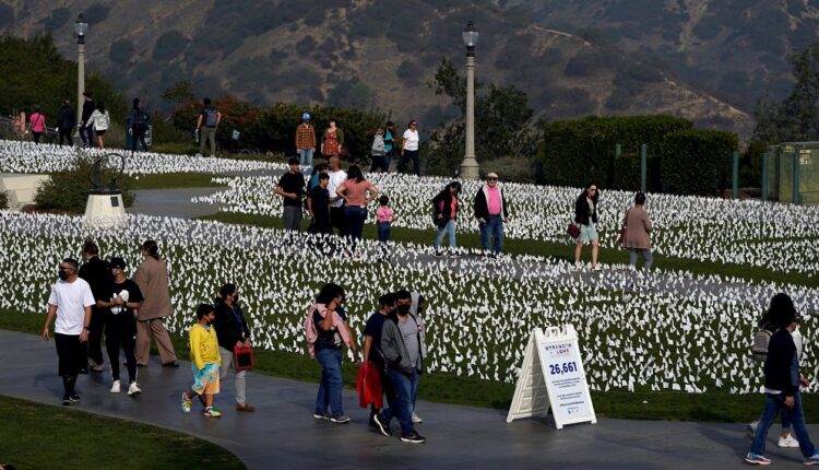 Visitors walk past a memorial for victims of COVID-19 at the Griffith Observatory, Friday, Nov. 19, 2021, in Los Angeles. (AP Photo/Marcio Jose Sanchez)