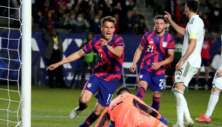 United States midfielder Cole Bassett, left, celebrates after scoring past Bosnia and Herzegovina goalkeeper Belmin Dizdarevic, bottom center, during the second half of an international friendly soccer match Saturday, Dec. 18, 2021, in Carson, Calif. (AP Photo/Marcio Jose Sanchez)