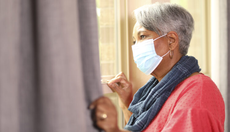 senior woman looks out window