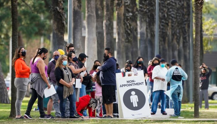 People wait in line to test for COVID-19 on Jan. 12, 2022, in Long Beach, Calif. (AP Photo/Ashley Landis)