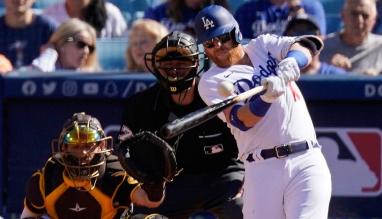Los Angeles Dodgers' Justin Turner, right, hits a solo home run as San Diego Padres catcher Austin Nola, left, and home plate umpire Ben May watch during the first inning of a baseball game Saturday in LA. (AP Photo/Mark J. Terrill)